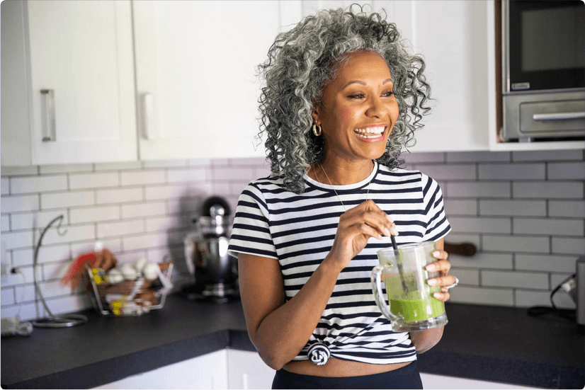 Healthy older woman drinking green smoothie